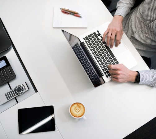 person using laptop on white wooden table